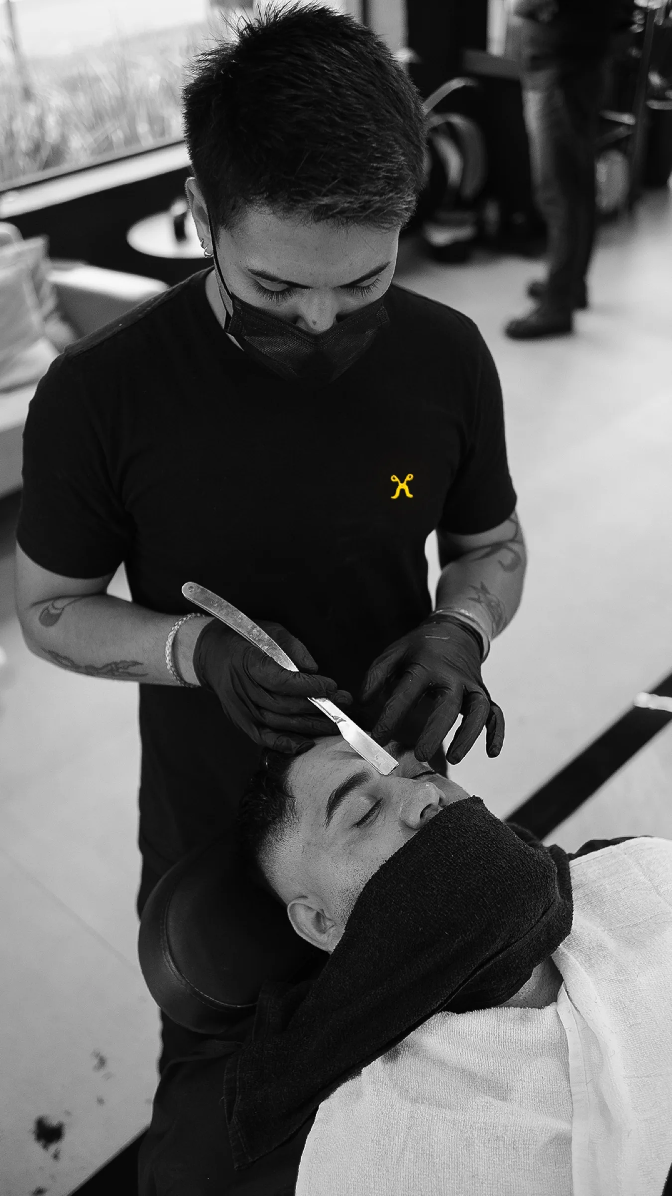 Barbeiro da A Banca realizando acabamento de barba com navalha