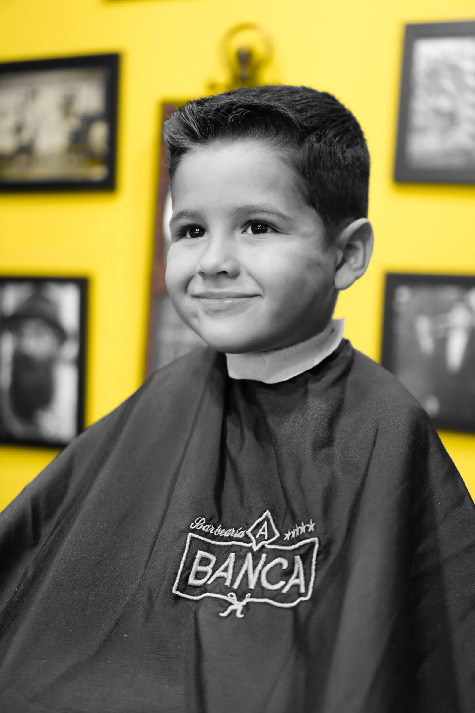 Criança sorrindo e exibindo o corte infantil finalizado na A Banca